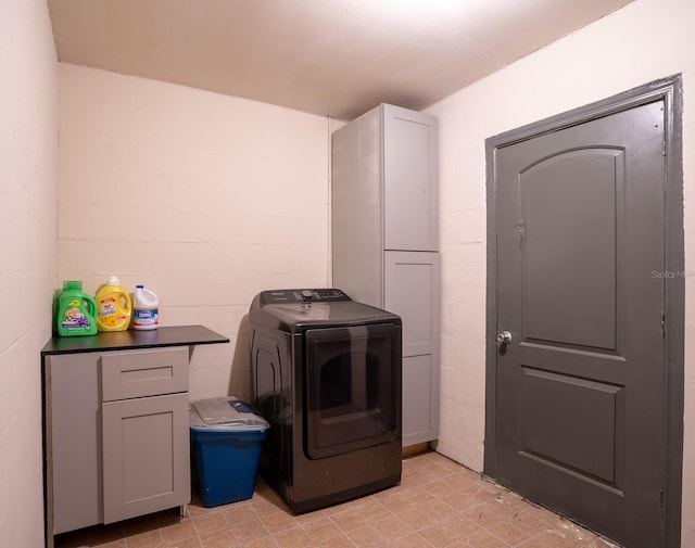 washroom featuring washer / clothes dryer, light tile patterned flooring, and cabinets