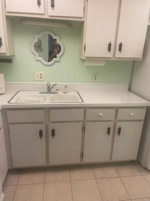 kitchen featuring sink and light tile patterned flooring