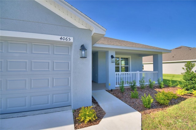 doorway to property featuring a porch and a garage