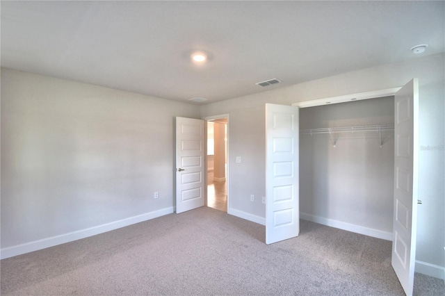 unfurnished bedroom featuring carpet and a closet