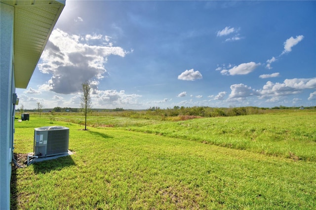 view of yard with a rural view and central air condition unit