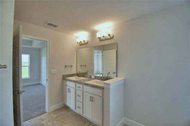 bathroom featuring tile patterned flooring, vanity, and a textured ceiling