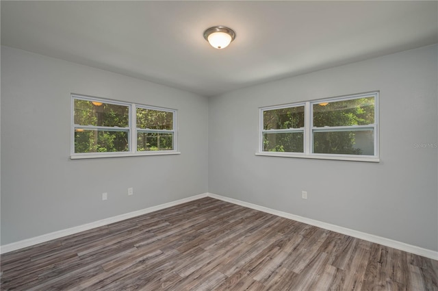 unfurnished room with plenty of natural light and dark hardwood / wood-style flooring