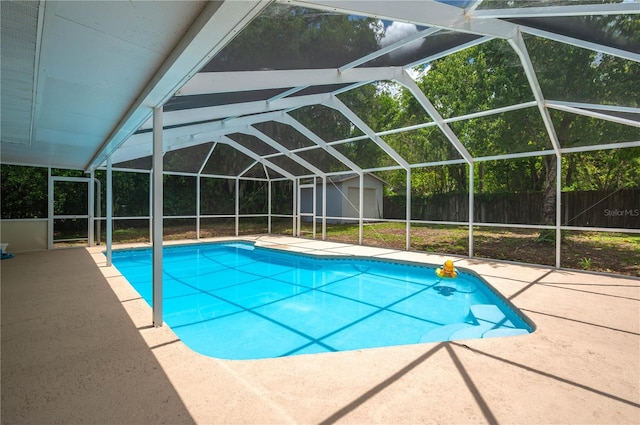 view of swimming pool with a lanai, a patio area, and a shed