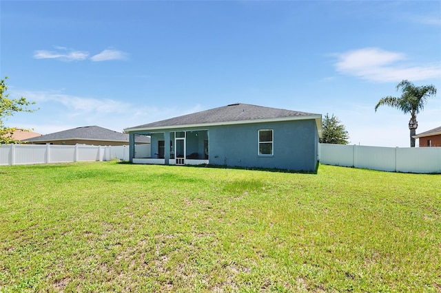 back of property featuring a fenced backyard, a lawn, and stucco siding