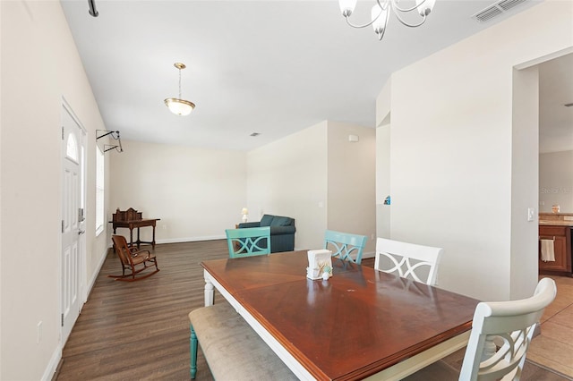 dining room with visible vents, a notable chandelier, baseboards, and wood finished floors