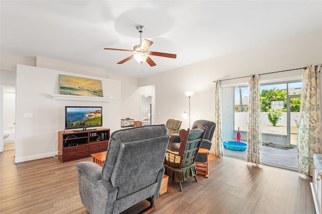 living room featuring ceiling fan, baseboards, and wood finished floors