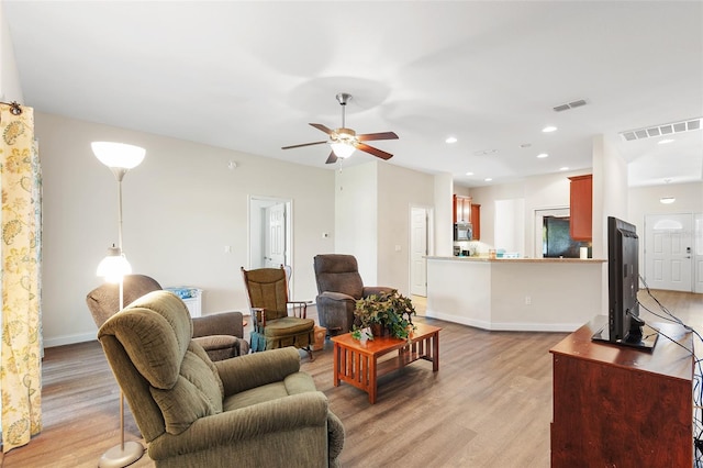 living area with light wood finished floors, visible vents, and recessed lighting