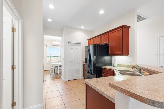 kitchen featuring light tile patterned flooring, recessed lighting, a sink, light countertops, and black refrigerator with ice dispenser