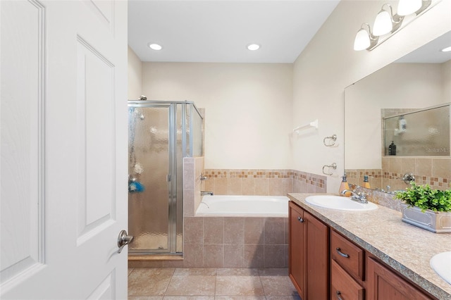 full bathroom featuring a bath, a shower stall, a sink, and tile patterned floors