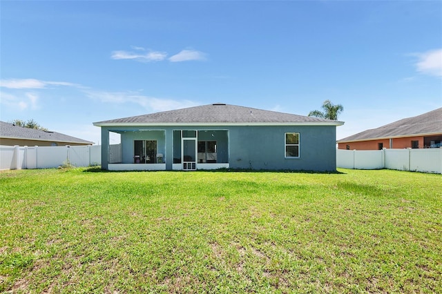 rear view of property with a yard, a fenced backyard, and stucco siding