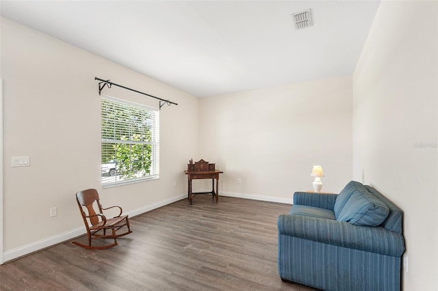 living area featuring wood finished floors, visible vents, and baseboards