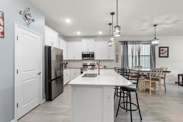 kitchen featuring sink, white cabinets, a center island with sink, and appliances with stainless steel finishes