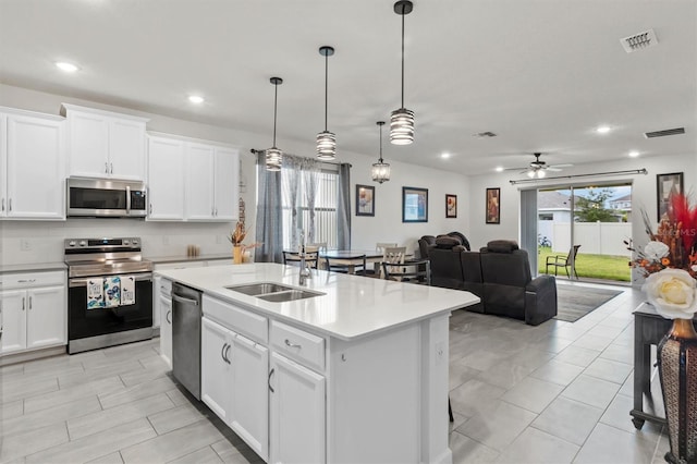 kitchen featuring a center island with sink, white cabinets, and appliances with stainless steel finishes