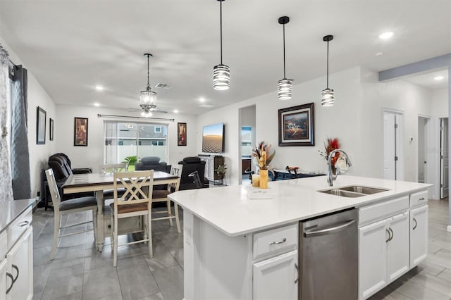 kitchen featuring white cabinetry, a kitchen island with sink, hanging light fixtures, and stainless steel dishwasher