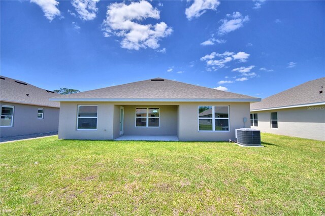 back of house with central AC and a yard