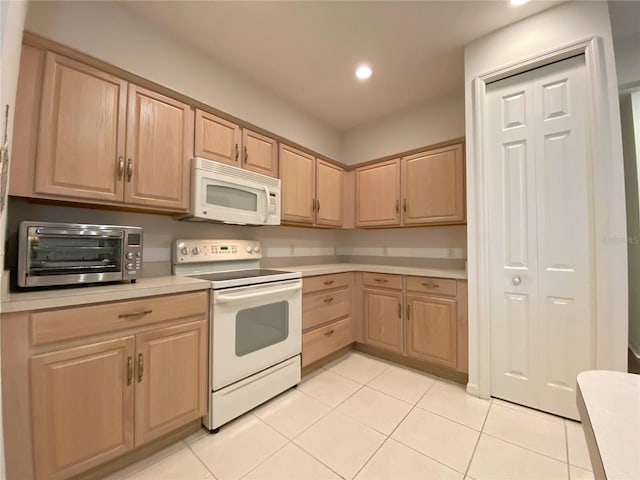 kitchen with white appliances, light tile patterned floors, and light brown cabinets