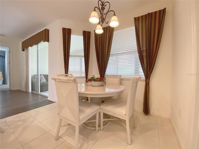tiled dining room with a notable chandelier