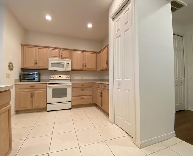 kitchen featuring white appliances, light brown cabinets, and light tile patterned flooring