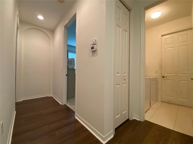 corridor with dark wood-type flooring and washer and clothes dryer