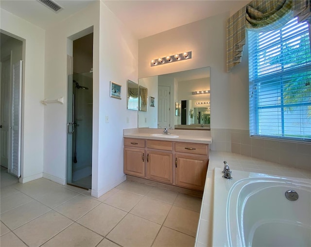 bathroom featuring tile patterned flooring, vanity, and plus walk in shower