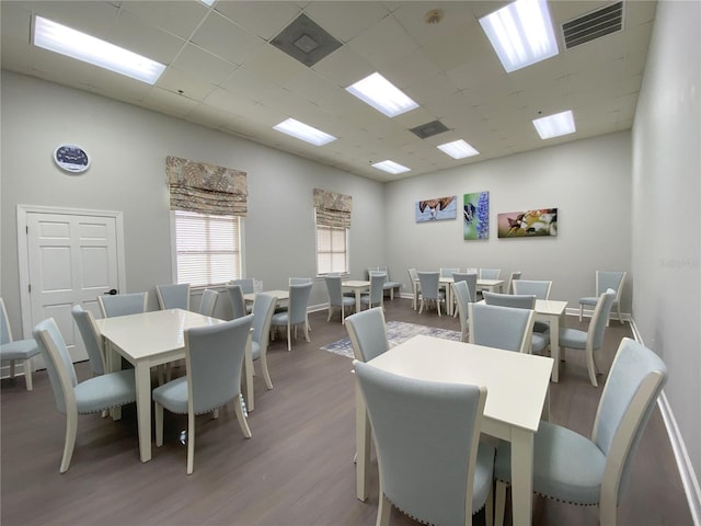 dining area with wood-type flooring and a paneled ceiling