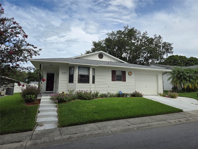 view of front of property with a front yard, central AC, and a garage