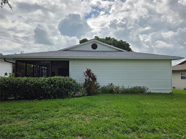 view of side of home with a yard and a sunroom