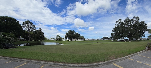 view of community with a water view and a yard