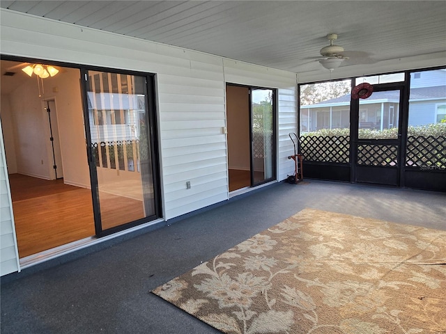 unfurnished sunroom featuring ceiling fan