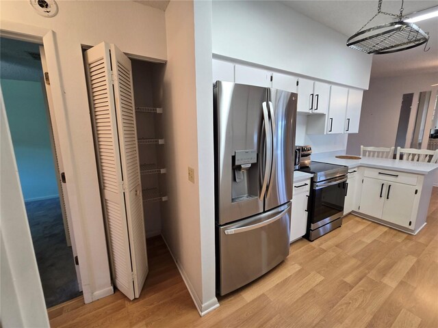 3130 Prairie Dunes Cir W, Lakeland, FL 33810 - kitchen with appliances with stainless steel finishes, light wood-style floors, a peninsula, light countertops, and white cabinets