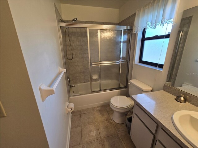 3130 Prairie Dunes Cir W, Lakeland, FL 33810 - bathroom featuring vanity, toilet, bath / shower combo with glass door, and tile patterned floors