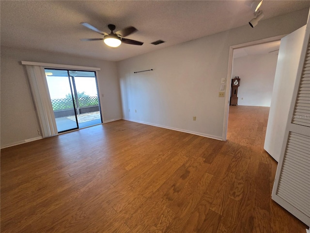 unfurnished room featuring ceiling fan, wood-type flooring, and a textured ceiling