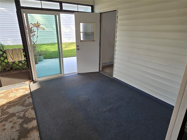 doorway to outside featuring dark carpet