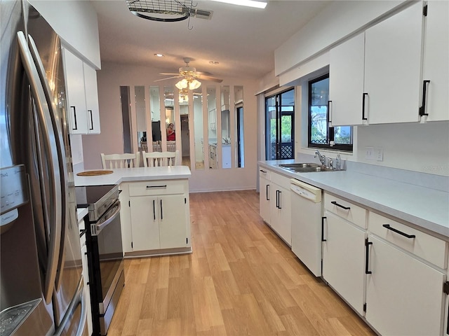 kitchen featuring white cabinetry, appliances with stainless steel finishes, sink, and light wood-type flooring