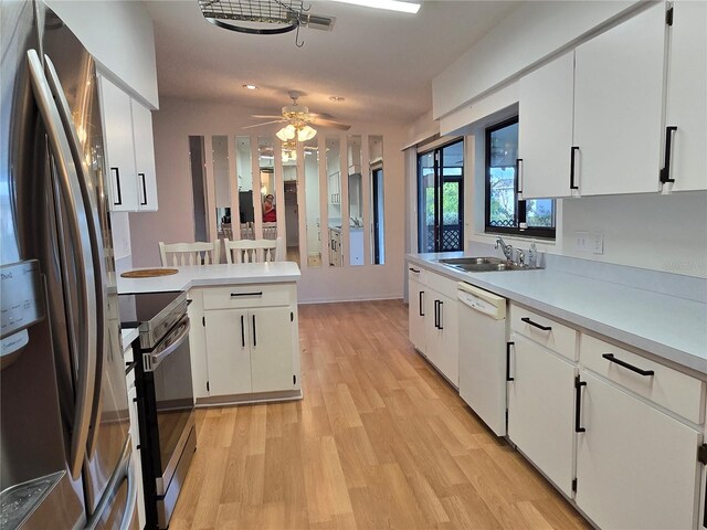 3130 Prairie Dunes Cir W, Lakeland, FL 33810 - kitchen with appliances with stainless steel finishes, a sink, a peninsula, light wood-type flooring, and light countertops
