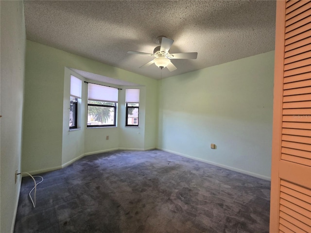 carpeted empty room with ceiling fan and a textured ceiling