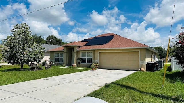 single story home featuring a garage, a front yard, and solar panels