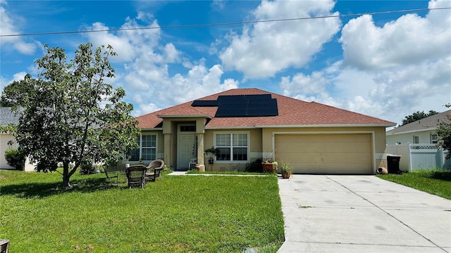 view of front of home featuring solar panels, a garage, and a front lawn