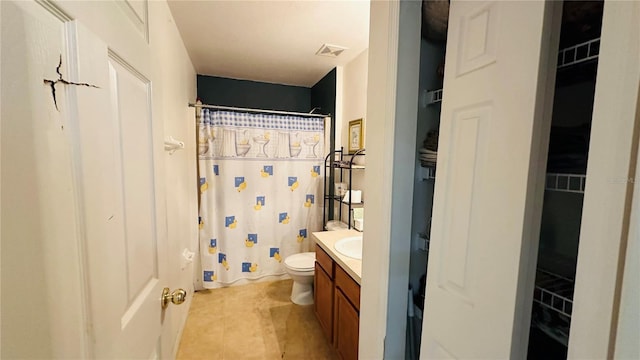 bathroom featuring tile patterned flooring, a shower with curtain, vanity, and toilet