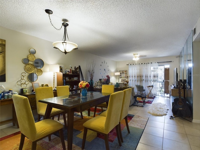 dining area with light tile patterned floors and a textured ceiling