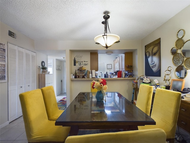 tiled dining area with a textured ceiling