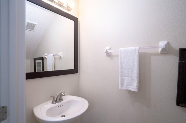 bathroom with sink and lofted ceiling