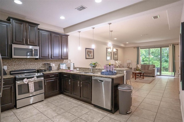 kitchen with backsplash, light stone countertops, appliances with stainless steel finishes, and kitchen peninsula