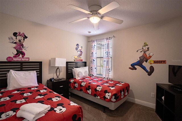 bedroom featuring dark colored carpet, a textured ceiling, and ceiling fan