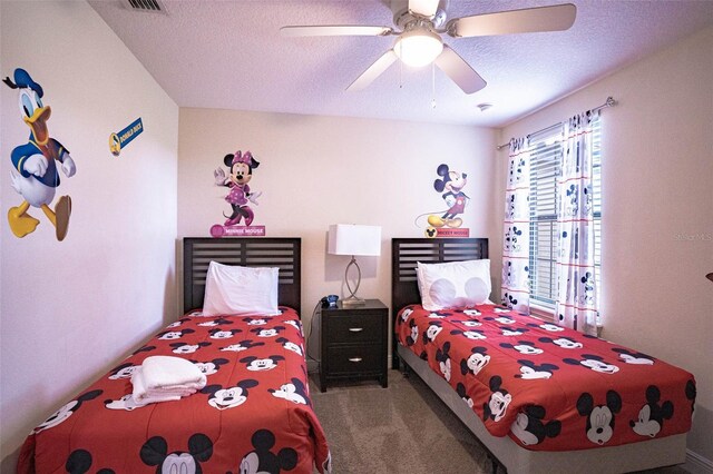 carpeted bedroom featuring a textured ceiling and ceiling fan