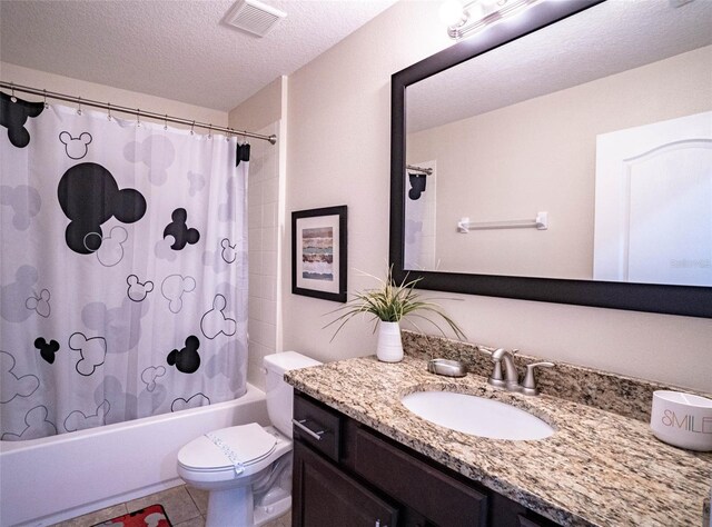 full bathroom featuring tile patterned flooring, a textured ceiling, shower / tub combo with curtain, toilet, and vanity