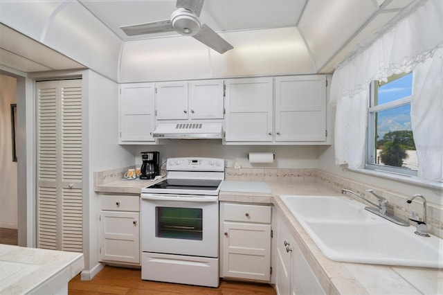 kitchen featuring sink, white cabinets, light hardwood / wood-style flooring, and white electric stove