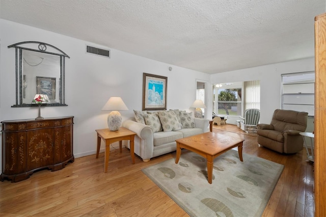 living room featuring a textured ceiling and light wood-type flooring