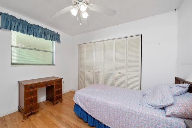 bedroom with ceiling fan, light hardwood / wood-style floors, and a closet